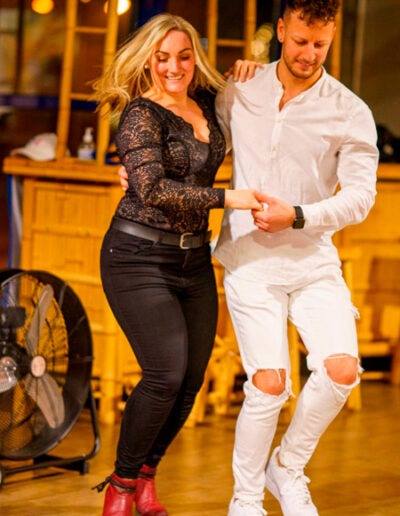 Tanzpaar nimmt an einem Salsakurs beim Tanzkurs Salsa Ulm teil. Der Mann hält die Hand der Dame im Rhythmus der Musik.